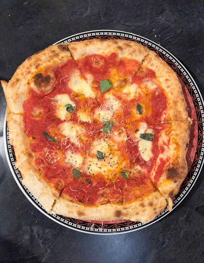 Margarhita pizza - red sauce with cheese and basil on a thick crust
